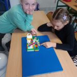 Uczennice bawiące się swoim modelem z klocków Lego